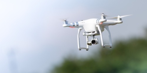 Drone volant avec caméra de surveillance en mouvement dans le ciel naturel.